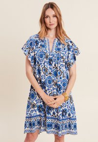 Blau-weißes Blumenkleid mit kurzen Rüschensäumen, V-Ausschnitt, kunstvollen Mustern und einem Saum mit dekorativen Rändern.