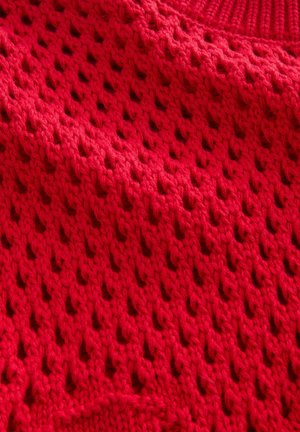 Tessuto lavorato a maglia rosso con motivo a lavorazione aperta, caratterizzato da dettagli testurizzati e un aspetto morbido e intrecciato.