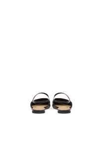 Schwarze Sandalen mit zwei schmalen Riemen und einer flachen Sohle. Das Fußbett ist beige und das gesamte Design ist minimalistisch und offen.