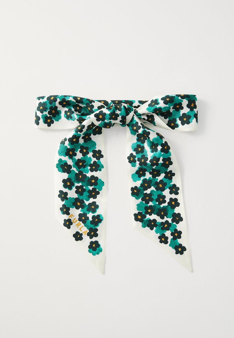 Gėlių šalikas su baltu fonu, mėlynomis gėlėmis ir juodais žiedų centrais, surištas į lanką su dviem ilgais, smailiais galais. Matoma auksinė ženklodara.