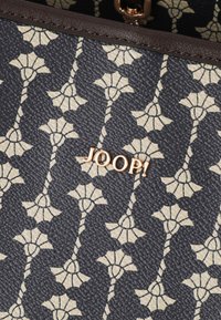 Borsa a mano a fantasia marina con superficie texture, caratterizzata da un design floreale ripetitivo in una tonalità più chiara e un logo metallico con la scritta "JOOP!".