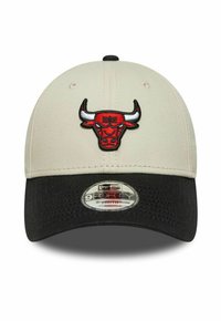 Casquette de baseball avec une couronne beige, une visière courbée noire et un logo de taureau rouge brodé à l'avant, avec un autocollant New Era 9FORTY Youth sur la visière.