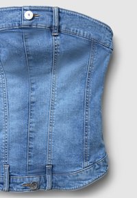 Top corsetto in denim di colore azzurro chiaro, con cuciture verticali, orlo inferiore arrotondato e un unico bottone metallico sul davanti per la chiusura.