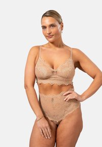 Spetsbralette och högmidjade trosor i nude-färg, med toppar i vågigt mönster och blommönster, samt justerbara axelremmar för bästa passform.