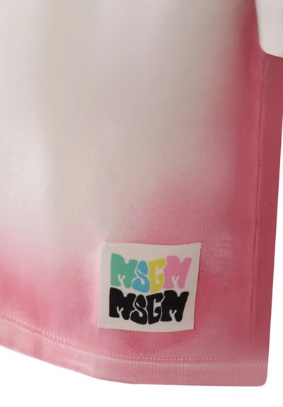 T-shirt con gradient che presenta una sfumatura di rosa chiaro con parte superiore bianca. Include un'etichetta rettangolare con il testo colorato "MSG". Materiale in cotone, texture liscia.