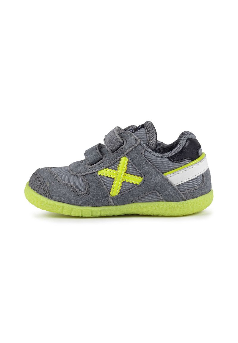 Scarpa per bambini grigia con tomaia in suede e rete, dettagli gialli, cinturini in Velcro e suola in gomma verde texturizzata.