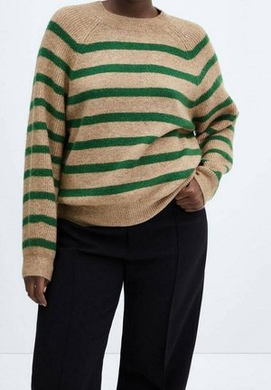 Beiger Pullover mit grünen horizontalen Streifen, geripptem Ausschnitt und weiten Ärmeln. Kombiniert mit lässigen, schwarzen Hosen. Weiche Textur sichtbar.
