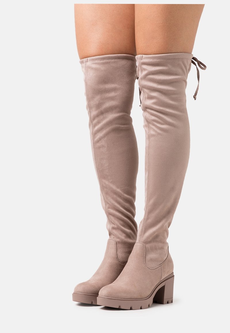 Knee-high, světle béžové, semišové boty s volným designem a malým blokovým podpatkem. Mají detaily se šněrováním na vrchu.