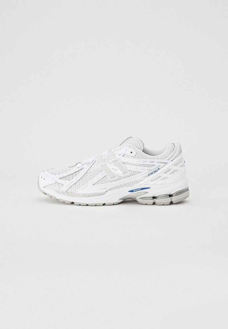 Chaussure de course blanche New Balance 1906R avec une tige en mesh et une semelle amortie, montrée de profil sur un fond clair uni.
