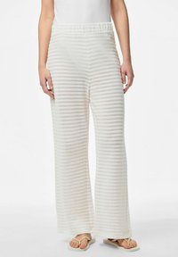 Pantalones blancos de pierna ancha con un patrón de rayas texturizado. Cintura elástica, tela ligera y un aspecto ligeramente translúcido.
