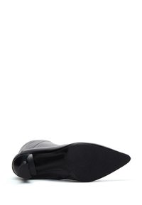 Zwarte enkellaars met een puntige neus, glad leren bovenwerk en een matte zwarte zool. Heeft een slank silhouette en minime hardware-accenten.