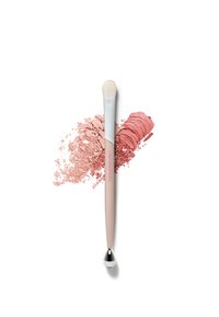 Make-upkwast met een zachte, witte harenkop, een taps toelopende beige greep en een metallic zilveren accent. Omringend roze poeder toont textuur en kleur.