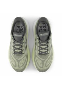 Baskets grises et vert clair avec une partie supérieure en maille texturée, bout rond, semelle rembourrée et lacets. Présente le logo "NB" sur la languette.