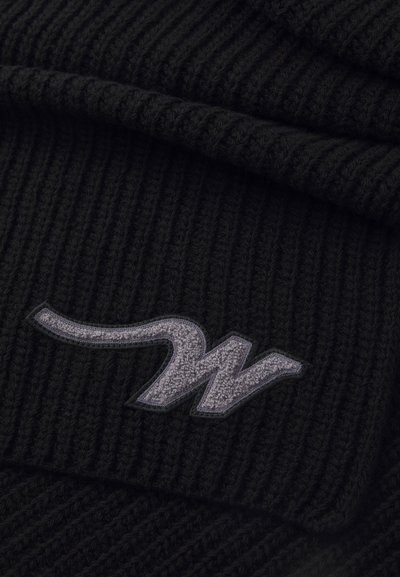 Bonnet en tricot côtelé noir avec un logo brodé gris. La texture est épaisse et chaude, avec un design replié.
