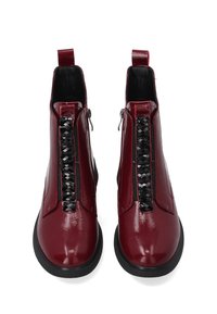 Bordeaux-farvede faux patent læder ankelstøvler med sort vævet detalje ved lynlåsen, der har en flad sål og en strop til nem påtagning.