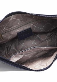 Granatowa nylonowa torba z zamkiem błyskawicznym, z beżową podszewką i powtarzającym się wzorem. Wewnątrz znajduje się kieszeń na zamek i firmowa metka.