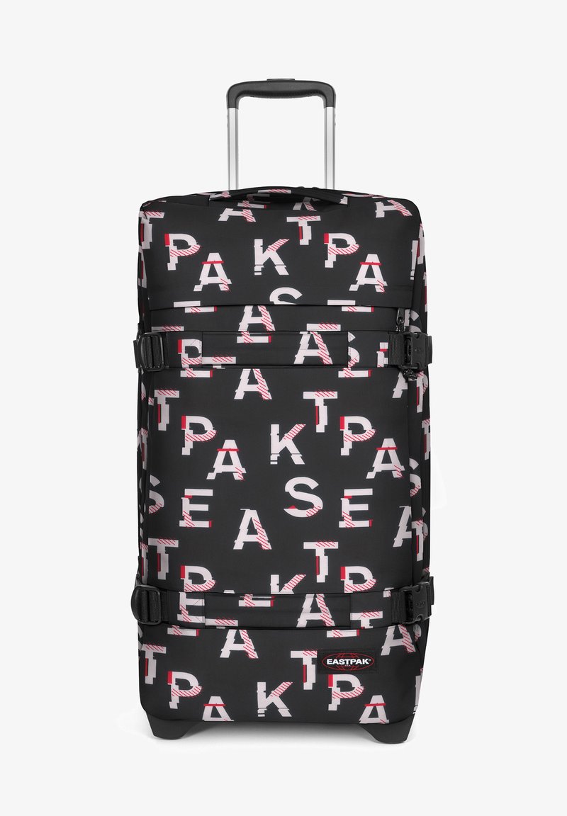 Musta pyörällinen matkalaukku, jossa on rohkeita, vuorotellen valkoisia ja punaisia kirjaimia toistuvassa kuosissa. Sisältää hihnoja ja vetokahvan.