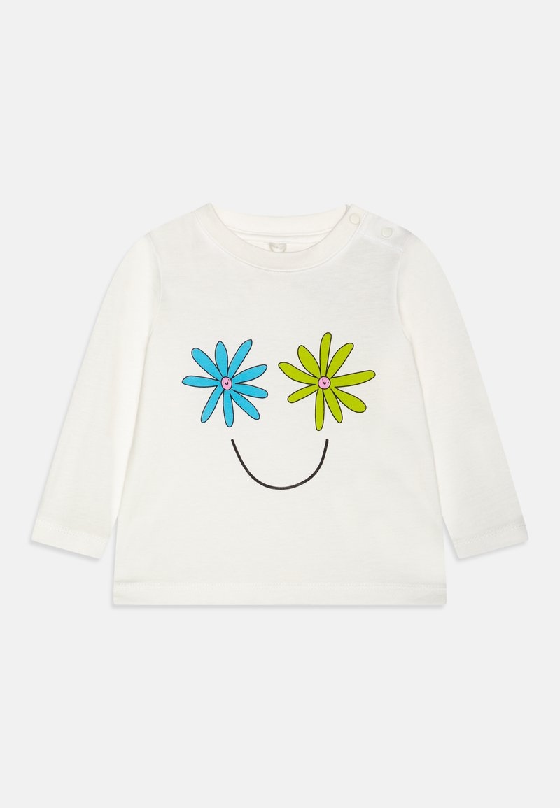 Hosszú ujjú fehér ing, mosolygós arc mintával, kék és zöld virágokkal a szemek helyén. Puha pamutból készült, patentos részletekkel.