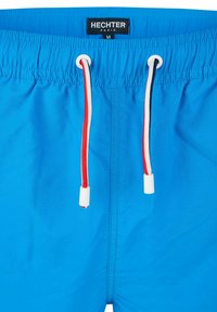 Shorts de bain bleus avec taille élastique, dotés de cordons de serrage rouges et blancs, et d'une étiquette portant "HECHTER PARIS" dans une position visible.