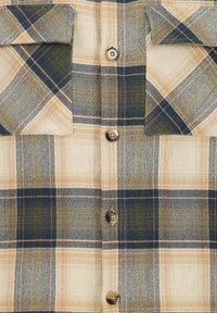 Karierte Button-Up-Hemd in Beige, Tan und Marineblau, mit zwei Brusttaschen, strukturierter Stoff und runden braunen Knöpfen.