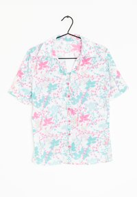 Camisa de manga corta, abotonada, en una tela ligera, con un patrón floral en rosa y turquesa sobre un fondo blanco.