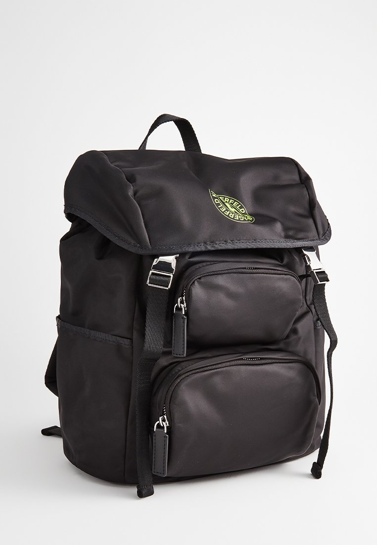 Czarny plecak nylonowy z rolowanym klapą, dwoma przednimi kieszeniami na zamek, regulowanymi paskami i zielonym akcentem w logo. Teksturowana powierzchnia.