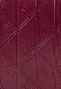 Burgundy tekstureret læder har et geometrisk mønster af overlappende cirkler og diamanter, med en subtil glans og præget detaljer.