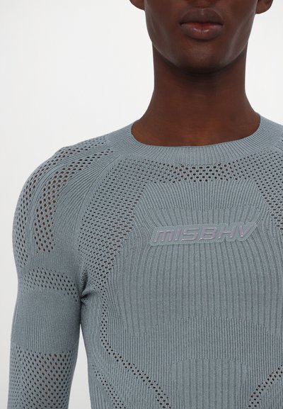 Gebreid langemouwen top in lichtblauw met een gestructureerd patroon en opengehaakte delen, met een verhoogd MISBHV-logo op de voorkant.