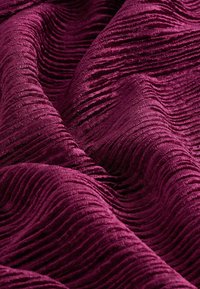 Tissu texturé bourgogne avec des rayures horizontales proéminentes et surélevées créant une apparence ondulante. Fini doux et moelleux.