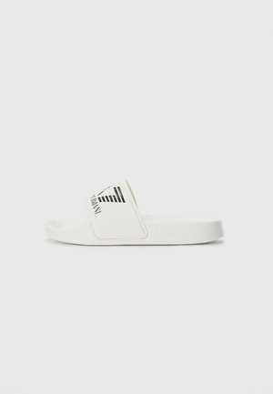 La ciabatta bianca presenta un cinturino testurizzato con un design del logo nero, una soletta liscia e una suola in gomma. Design minimalista con linee pulite.