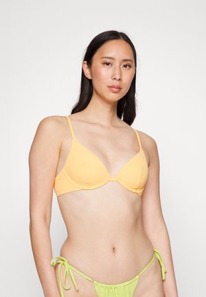 Top de bikini amarelado com aro, de textura canelada e alças ajustáveis, combinado com um fundo de bikini verde com cordões laterais, exibindo uma textura suave.