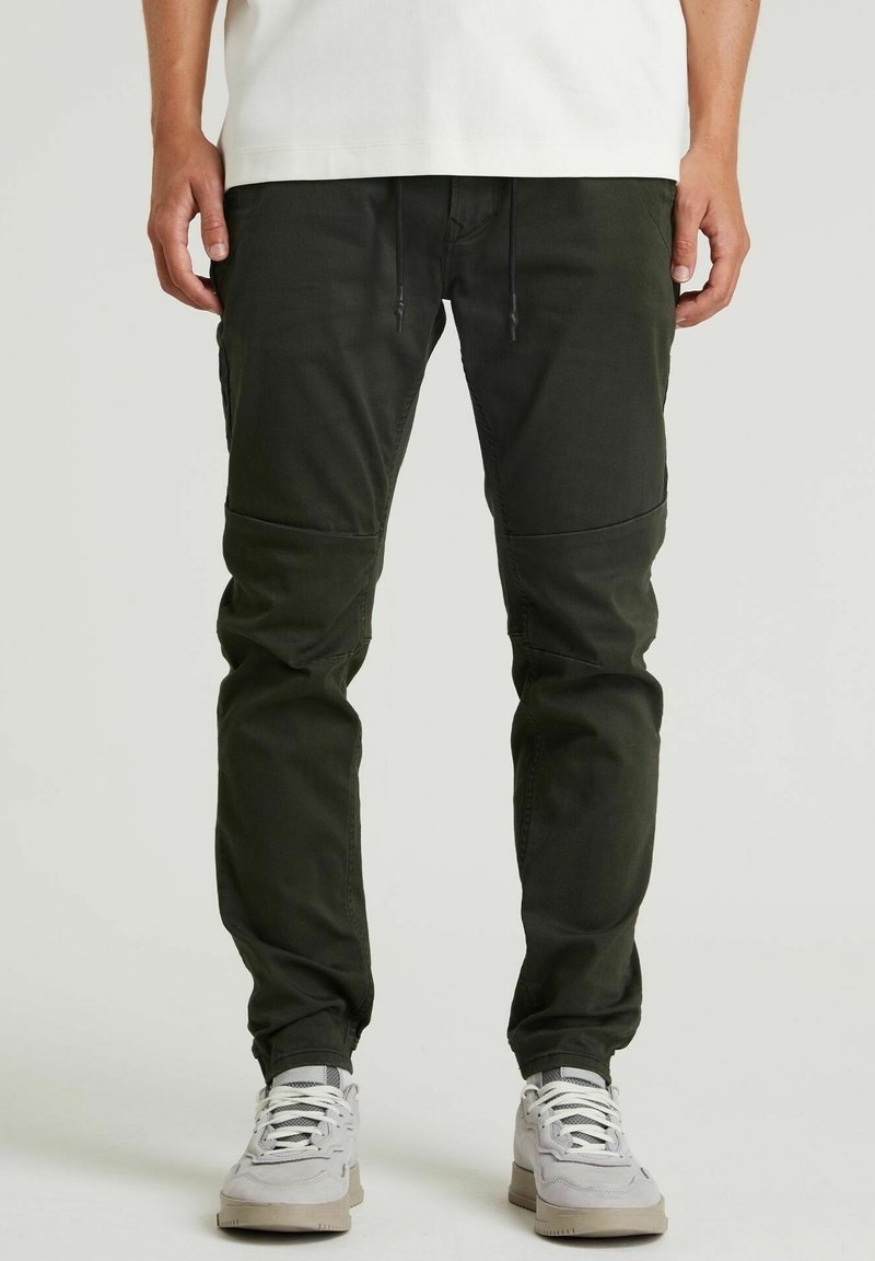 Mörkgröna cargobyxor med tapered ben, försedda med cargofickor, elastisk midja med dragsko och en mjuk bomullsblandning.