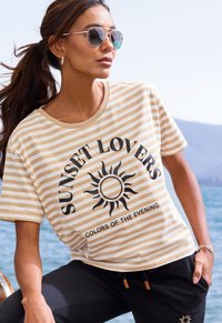Striped short-sleeve T-shirt in beige and white with a sun graphic and text "SUNSET LOVERS" and "COLORS OF THE EVENING." Cotton fabric.