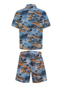 Set di maglietta a maniche corte e pantaloni corti, con uno sfondo blu e modelli floreali tropicali e paesaggistici in tonalità di arancione e verde.
