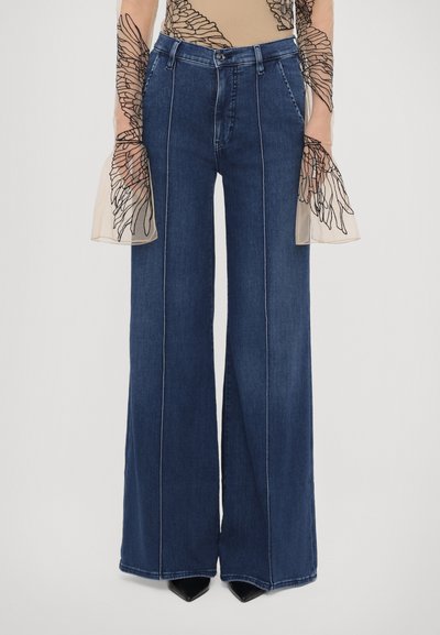Wide-leg denim jeans with a dark blue wash. Features visible stitching, side pockets, and a high waist design. Smooth texture.