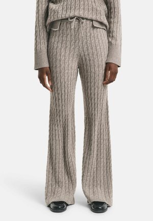 Grijze gebreide lounge-outfit set met gestructureerde kabelpatronen, relaxte wijde broekspijpen en een bijpassende trui met een ribbelkraag.