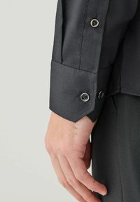 Ciemnoszara koszula z mankietem o teksturowanym wykończeniu, z kontrastowymi czarnymi guzikami i eleganckim, nowoczesnym krojem.