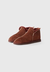 Brown suede ankle boots featuring a soft, textured lining, exposed stitching, and a low-profile rubber sole.