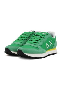 Sneakers atletici verdi con materiale in camoscio e rete, dotati di un logo bianco, suola nera in gomma e un accent in giallo sul tallone.