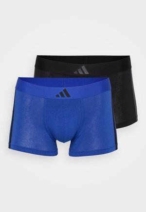 Kaksi paria bokserihousuja: yksi sininen sinisellä vyötärönauha, jossa on mustia yksityiskohtia, ja yksi musta mustalla vyötärönauhalla.