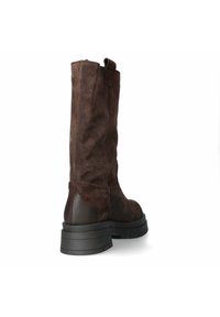 Stivale al ginocchio in suede marrone con design affusolato, suola piatta in gomma nera e una linguetta nella parte superiore per una facile calzata.