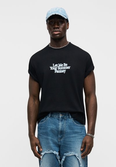 Čierne bavlnené tričko s bielym nápisom „Dovoľ mi byť tvojím letným snom“, doplnené svetlomodrými ošúchanými džínsami a rifľovou čiapkou.