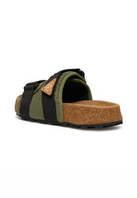 Green and black sandal with a textured cork sole, featuring a padded upper and a brown accent with stitching detail. Adjustable straps included.