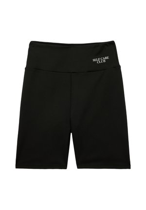 Shorts da ciclismo neri a vita alta con "SELF CARE CLUB" stampato in bianco sulla fascia superiore sinistra.