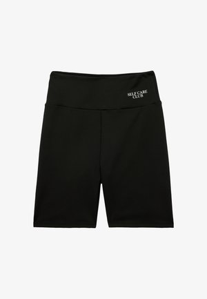 Shorts da ciclismo neri a vita alta con "SELF CARE CLUB" stampato in bianco sulla fascia superiore sinistra.