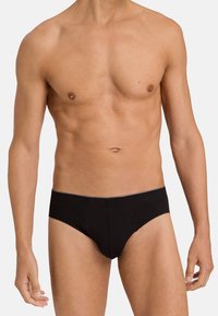 Schwarzes Baumwollslip mit einem tief sitzenden Design, das eine glatte Textur und eine minimalistische einfarbige Optik aufweist. Schlichter Bund mit dezentem Akzent.