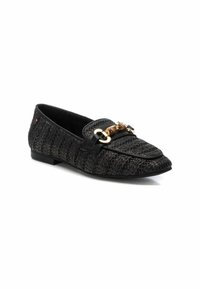 Mocasín negro trenzado con suela plana, detalles en cuero y una cadena dorada en la parte delantera. Superficie texturizada con punta puntiaguda.