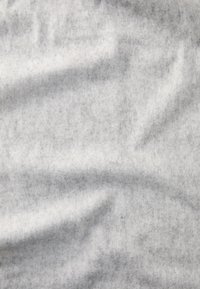 Grå filtstof med en blød tekstur, der har en glat, let broget overflade og subtile variationer i nuancen over hele stoffet.