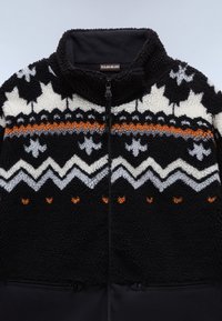 Giacca in pile nera con motivi geometrici bianchi e grigi, dotata di una striscia arancione, colletto alto e tasche con zip nella parte inferiore.