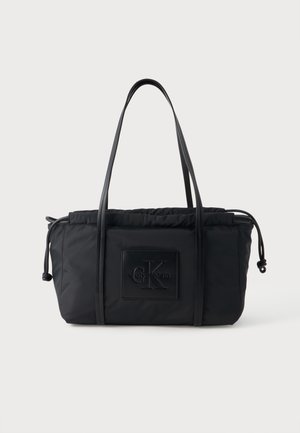 Czarna torba na ramię Calvin Klein ze ściągaczem i długimi cienkimi uchwytami, z wytłaczaną naszywką z logo z przodu.